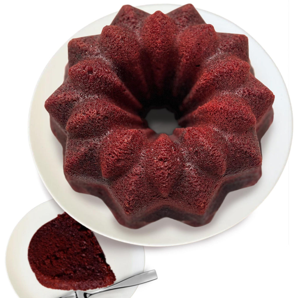 Red velvet bundt cake on a white plate with a slice removed.