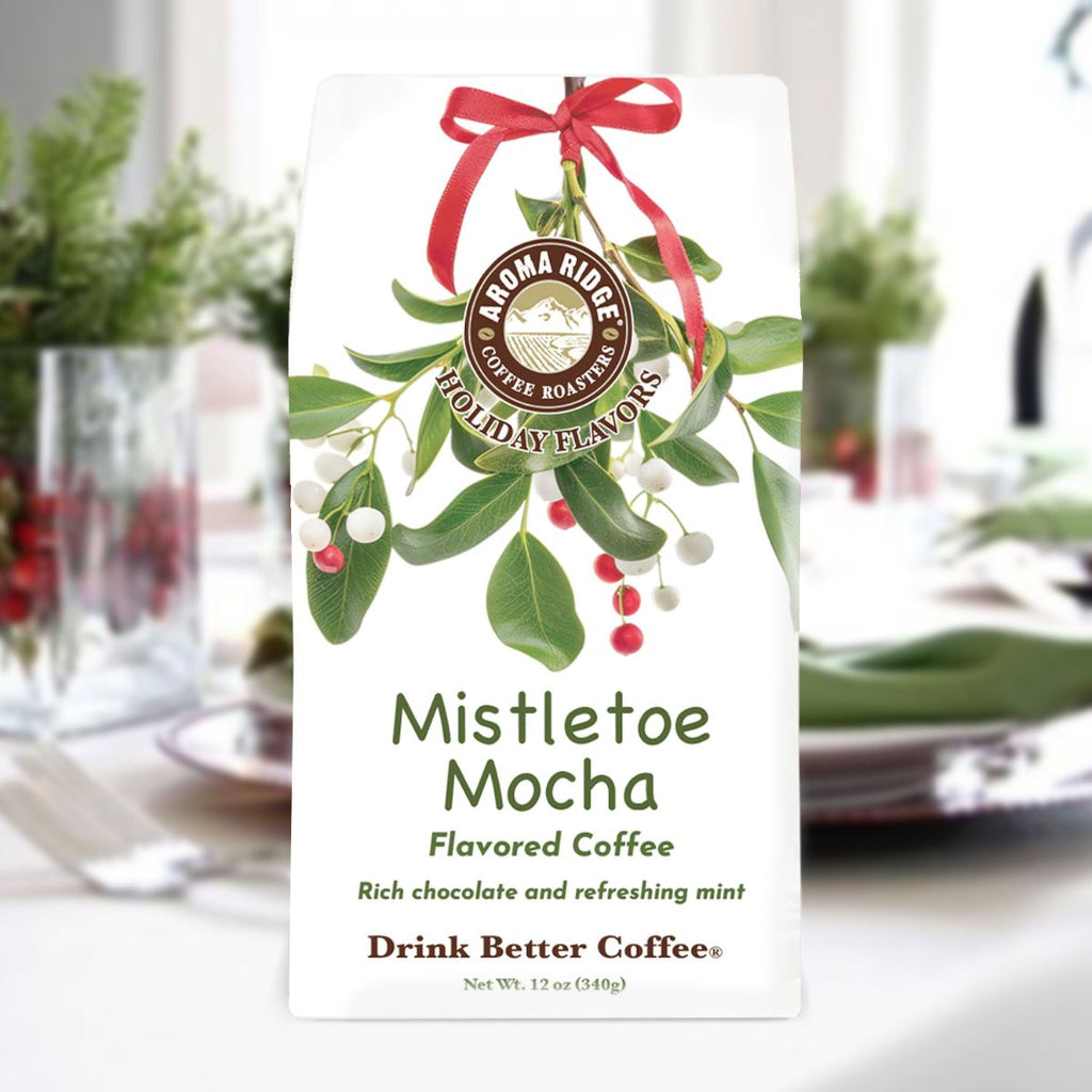 Aroma Ridge Mistletoe Mocha flavored coffee package with a festive design on a blurred holiday table setting.